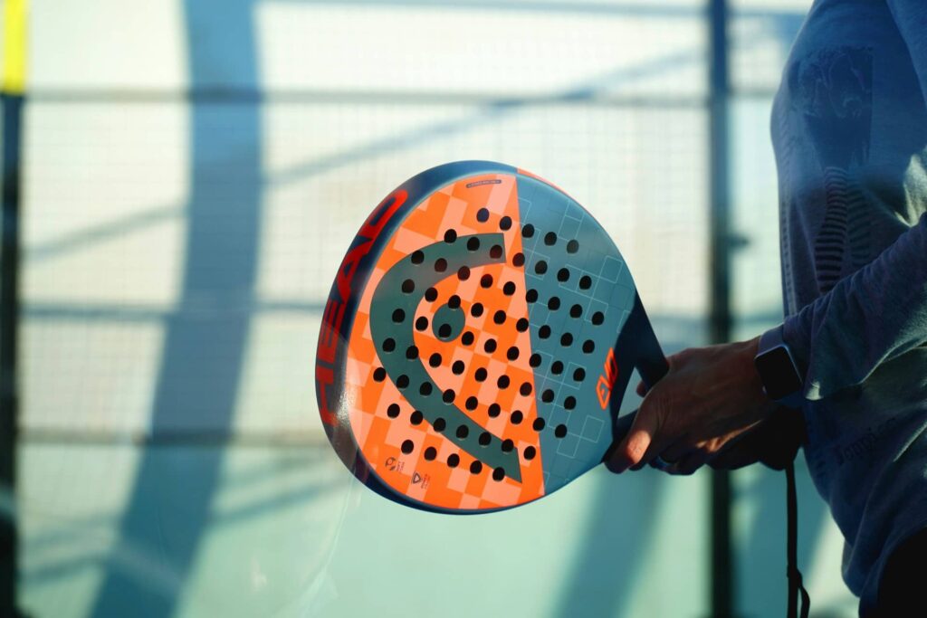 personne tenant une raquette de padel